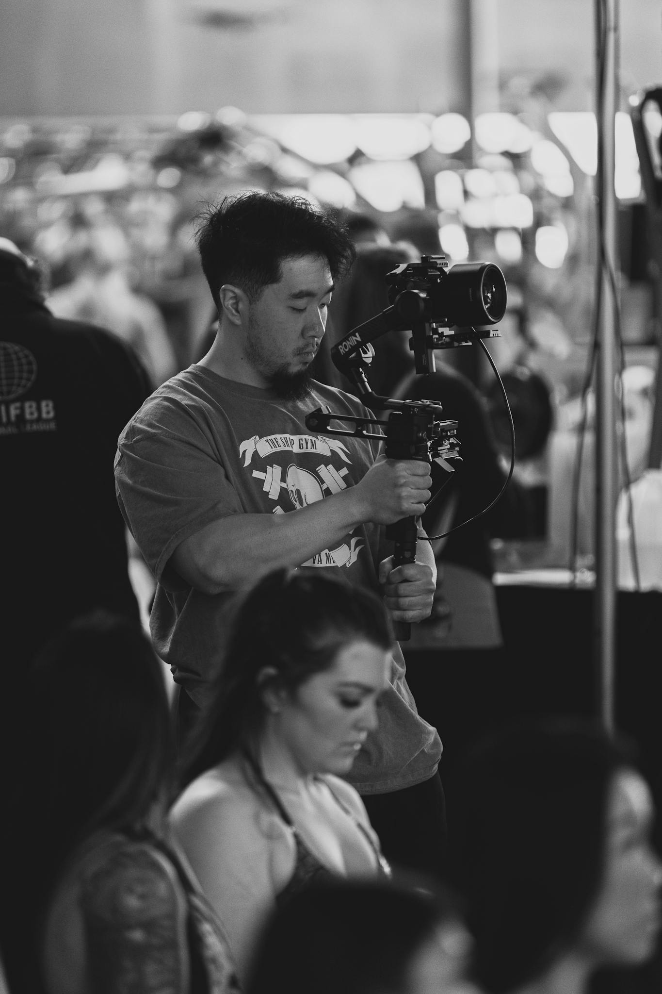 A camera operator films a live performance, capturing the essence of the event.